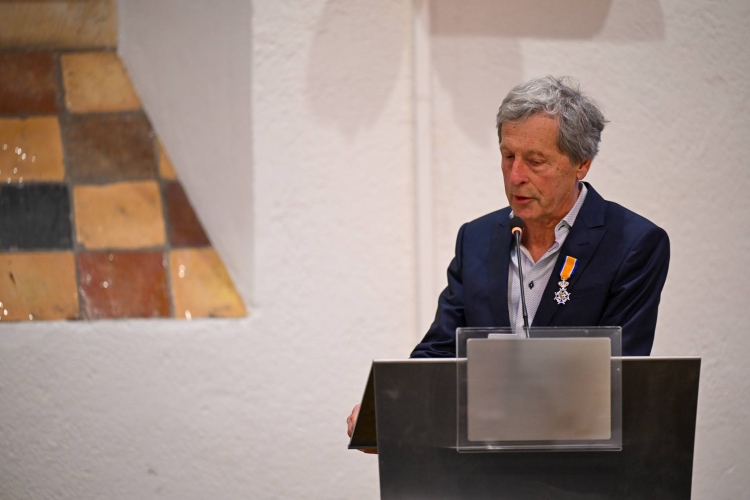 Bert Jansen spreekt de zaal toe. De onderscheiding is opgespeld op zijn jasje.