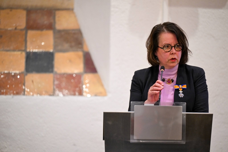 Marjolein Moester spreekt de zaal toe. De onderscheiding is opgespeld op haar jasje.